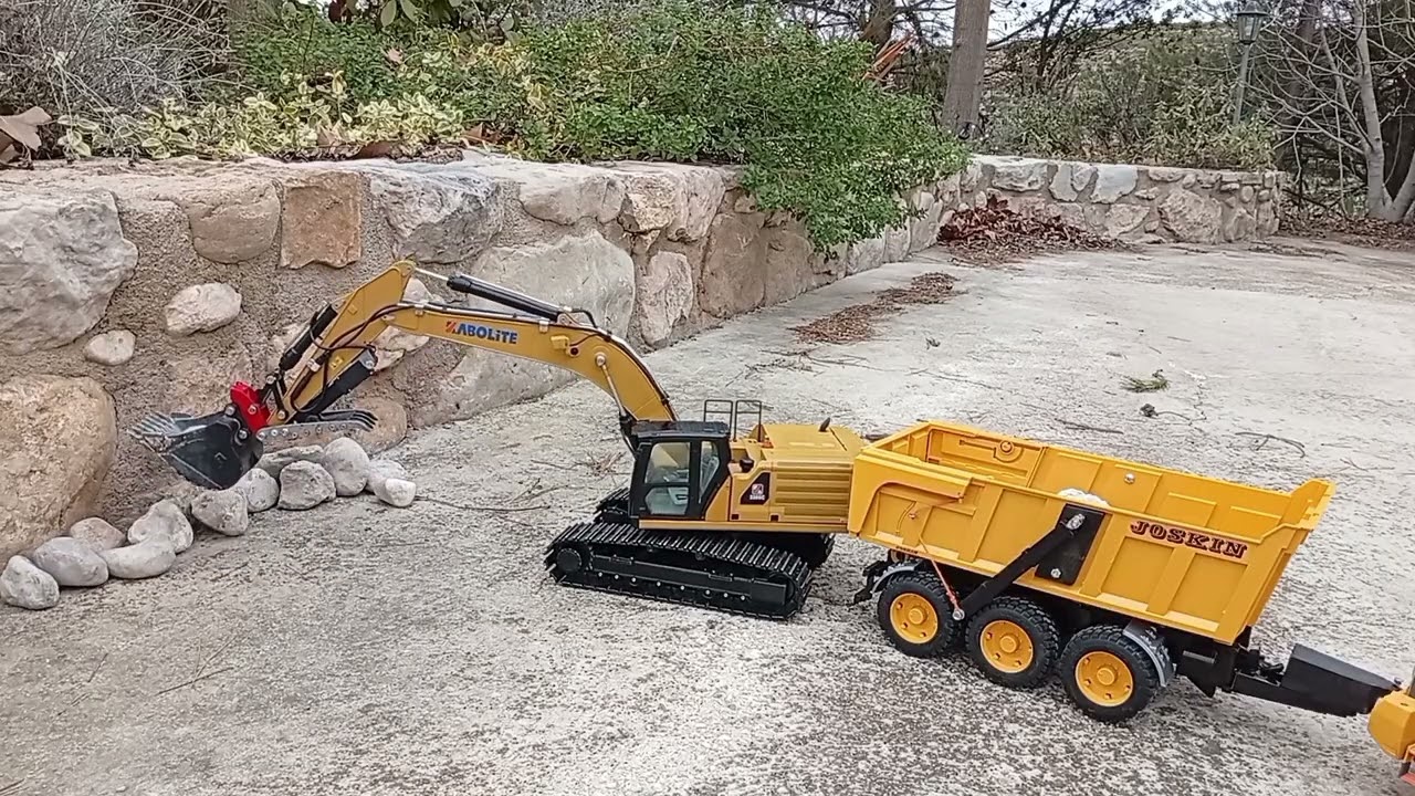 Kabolite 961. Flatbed trailer. Loading rocks with reversed bucket.
