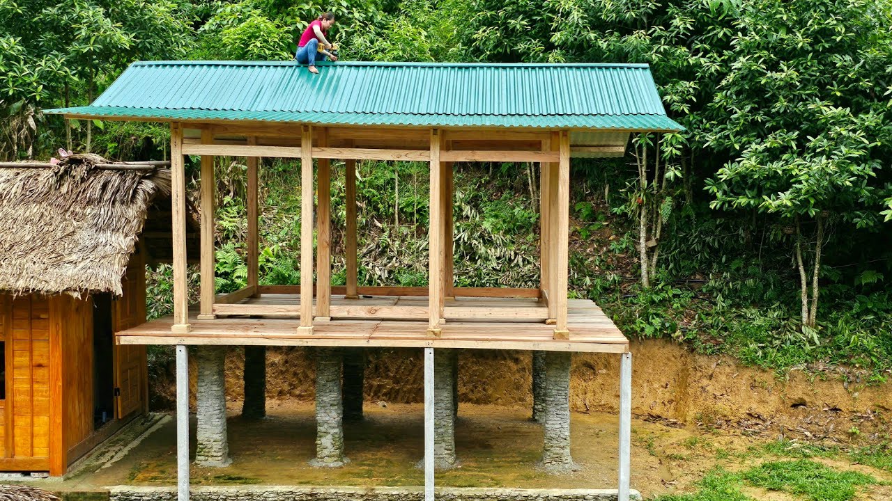 Beautiful girl build a roof for a new wooden house with green corrugated iron - Phùng Thị Chài