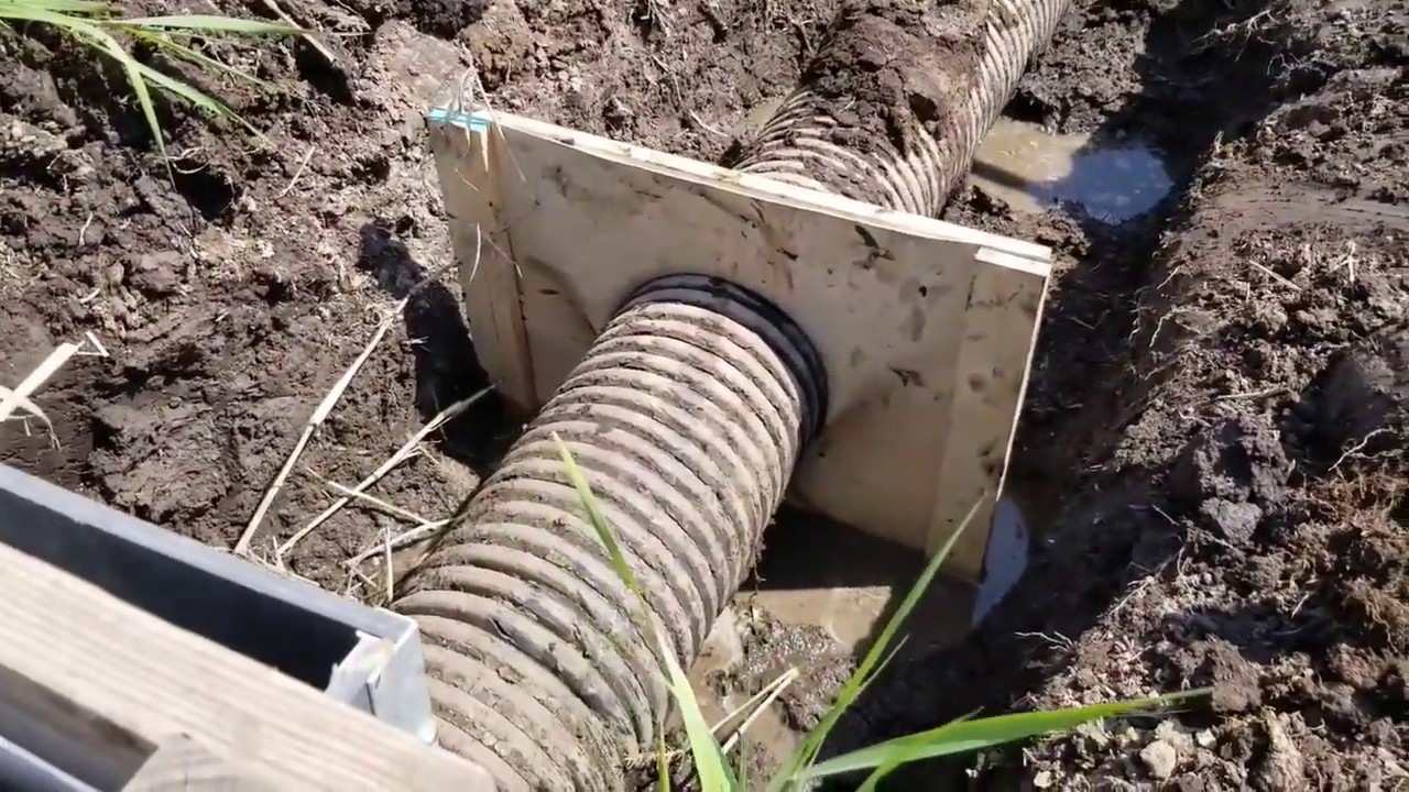 Hand digging pipe & anti seep install. Correction - Cut hole about 2/3rds the size of pipe.