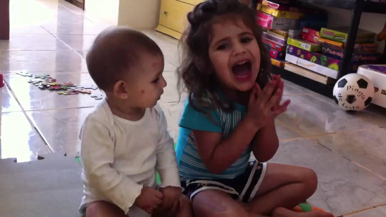 Alice e Isabela batendo palmas e cantando 