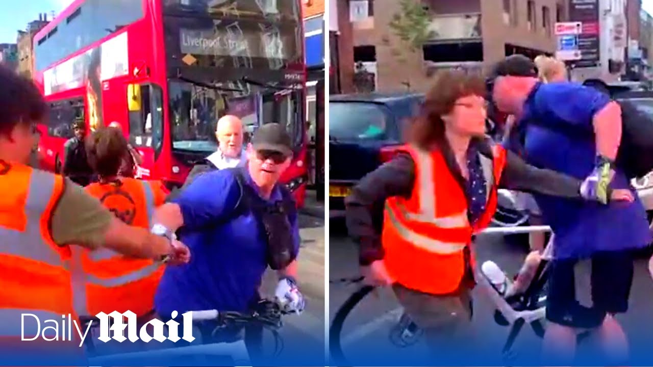 'Get out of the f****** way!' Cyclist drags protestors out of the road one by one