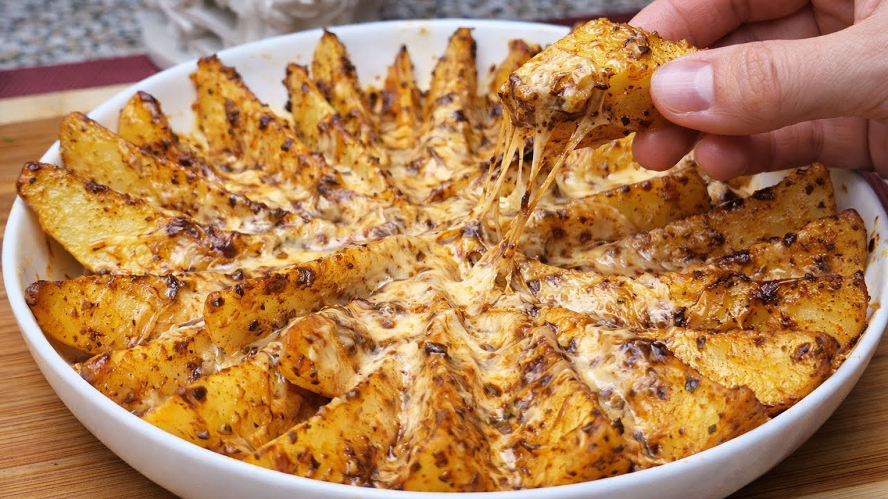 Сочные запеченные в духовке картофельные дольки с сыром, мягкие внутри, хрустящие снаружи.