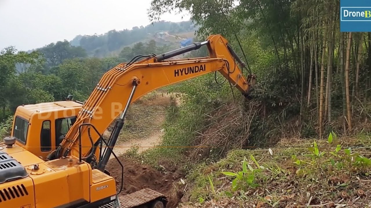 Clearing Bamboo Trees and Cutting Hillside for Wider Mountain Road while Backhoe Levels it