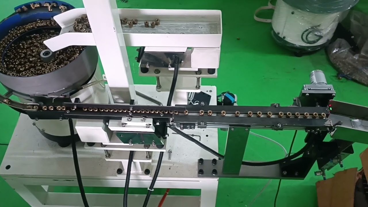Brass nut feeding system for laser marking.