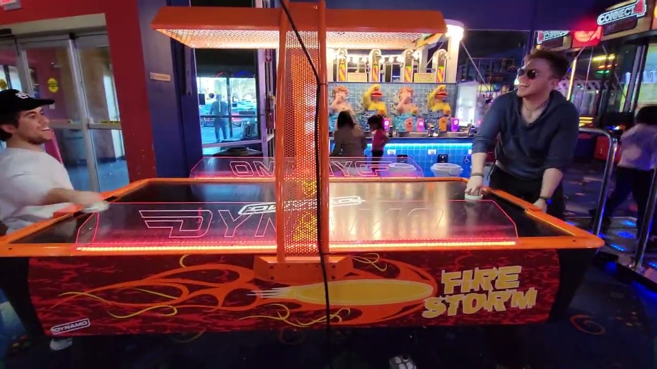An epic air hockey clash between: Hat Guy (left) and Indoor Sunglasses (right). 3 . 2 . 1 . Fight!