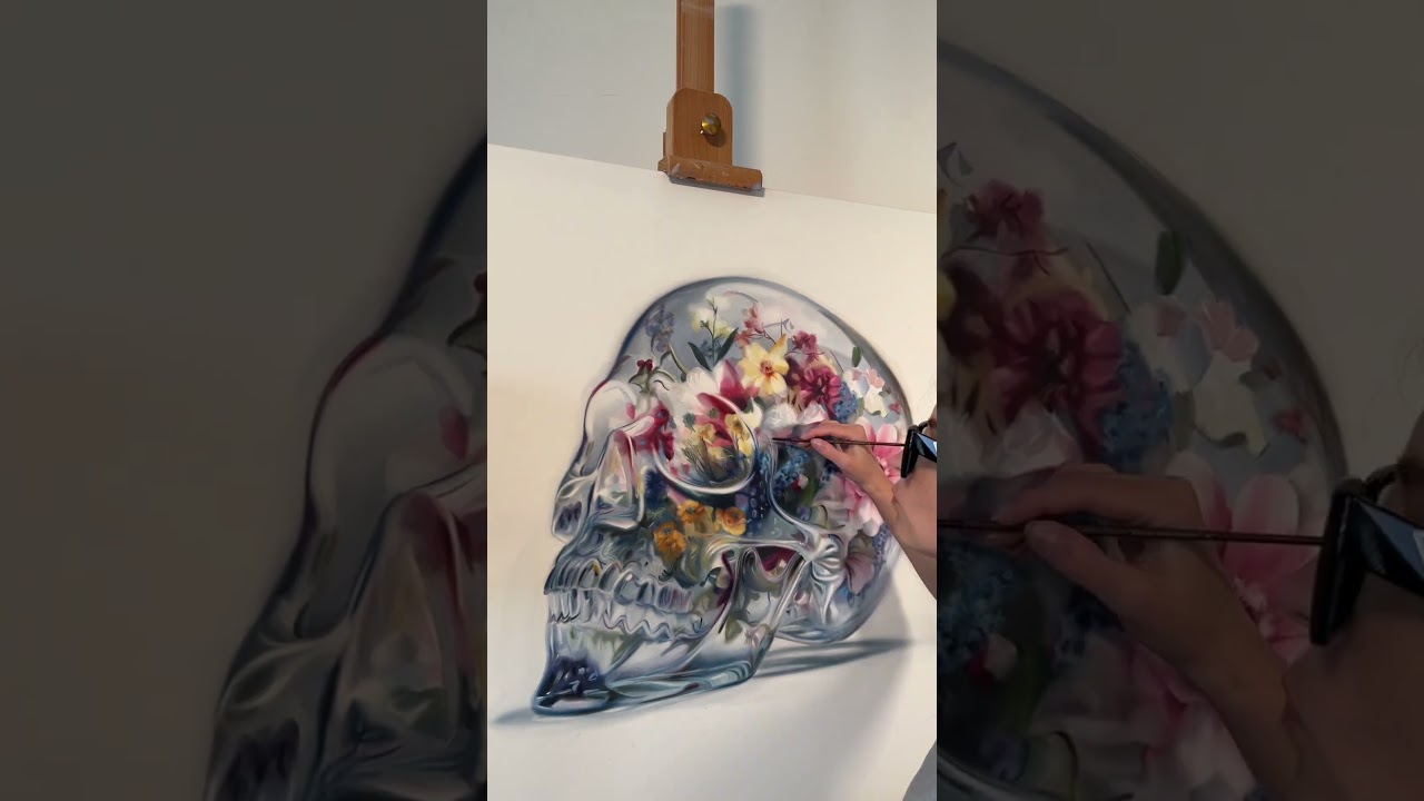 a glass skull filled with blooming flowers oilartist 