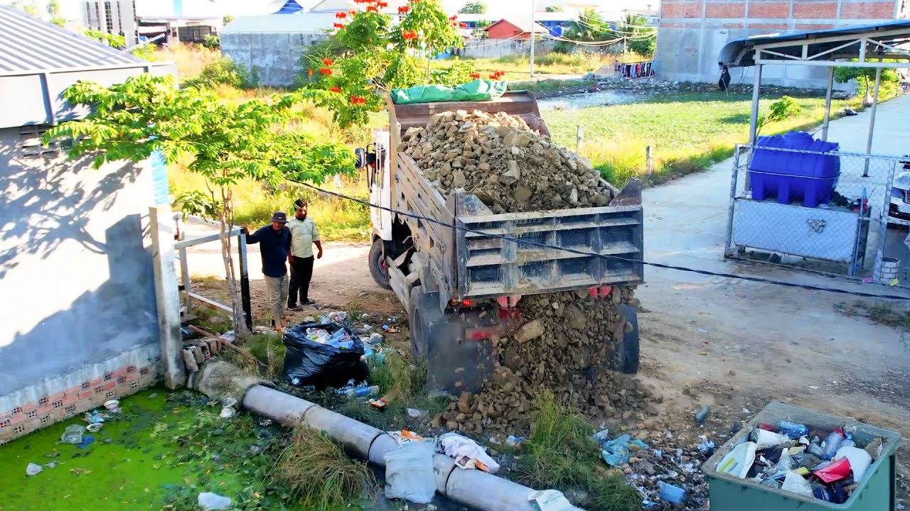 Cover drain by bulldozer and excellent driver push stone connect with dump truck unload
