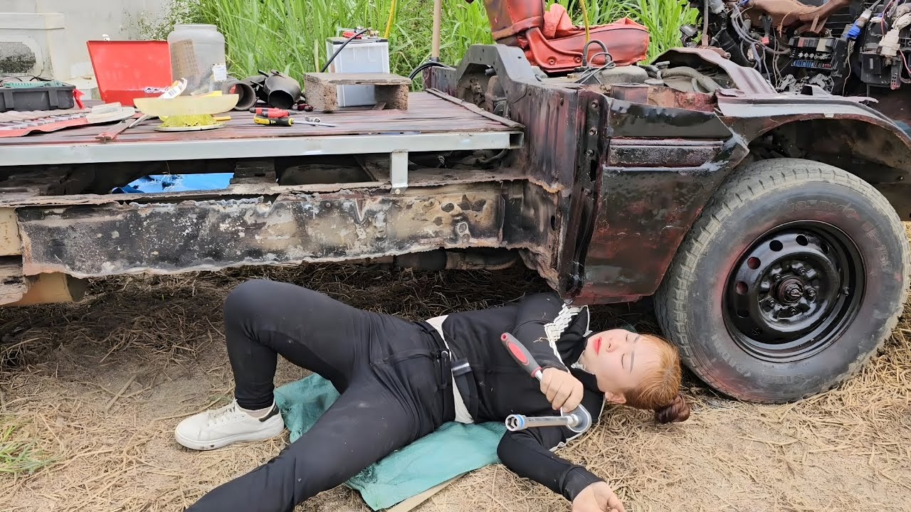 The girl repairs and perfects scrap cars for her neighbor.