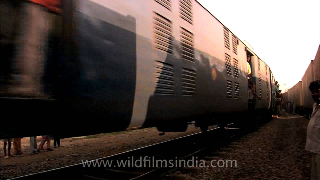 Black smoke billowing out of the engine in an Indian rail