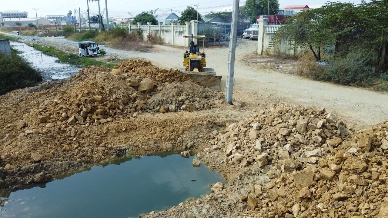 Impressive action! Dump trucks and Komatsu dozer working together to move stone and soil efficiently