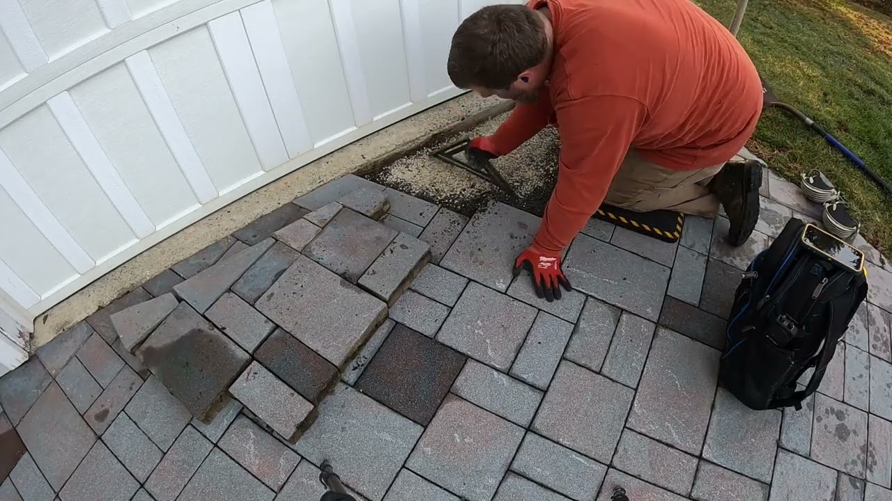 Repairing sinking pavers on a driveway. 