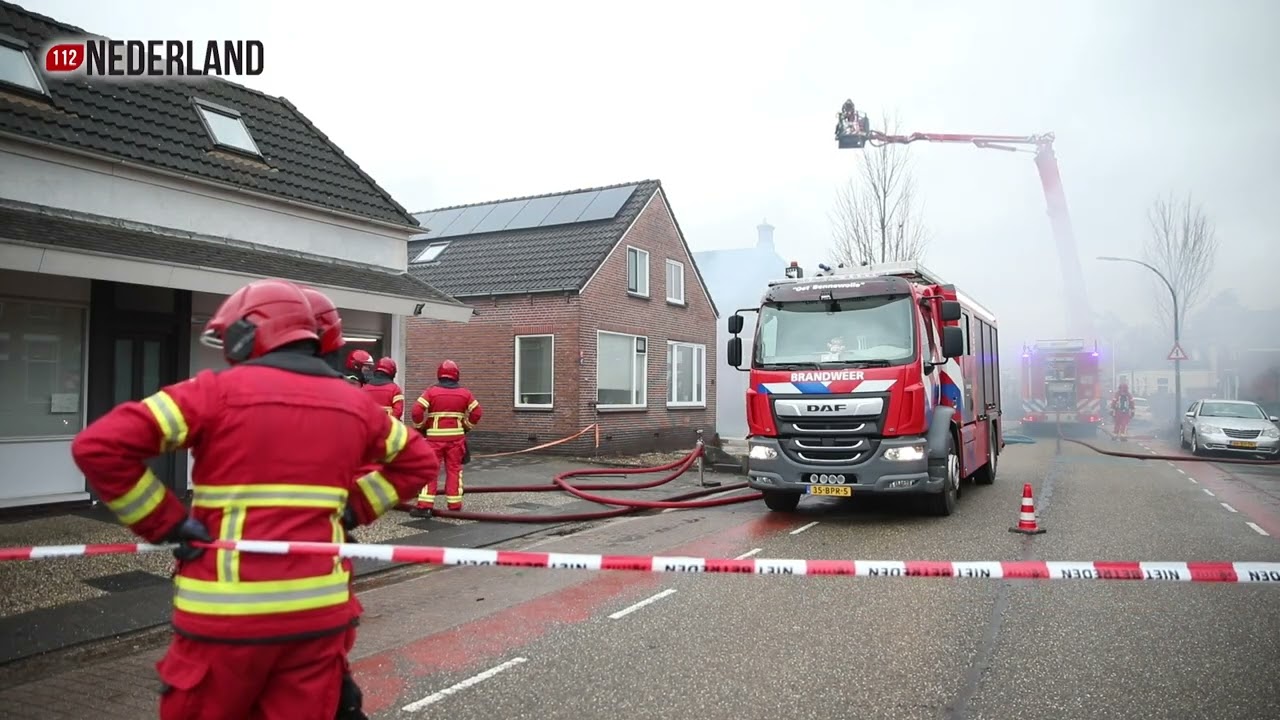 Grote uitslaande brand in loods, rook in wijde omgeving zichtbaar
