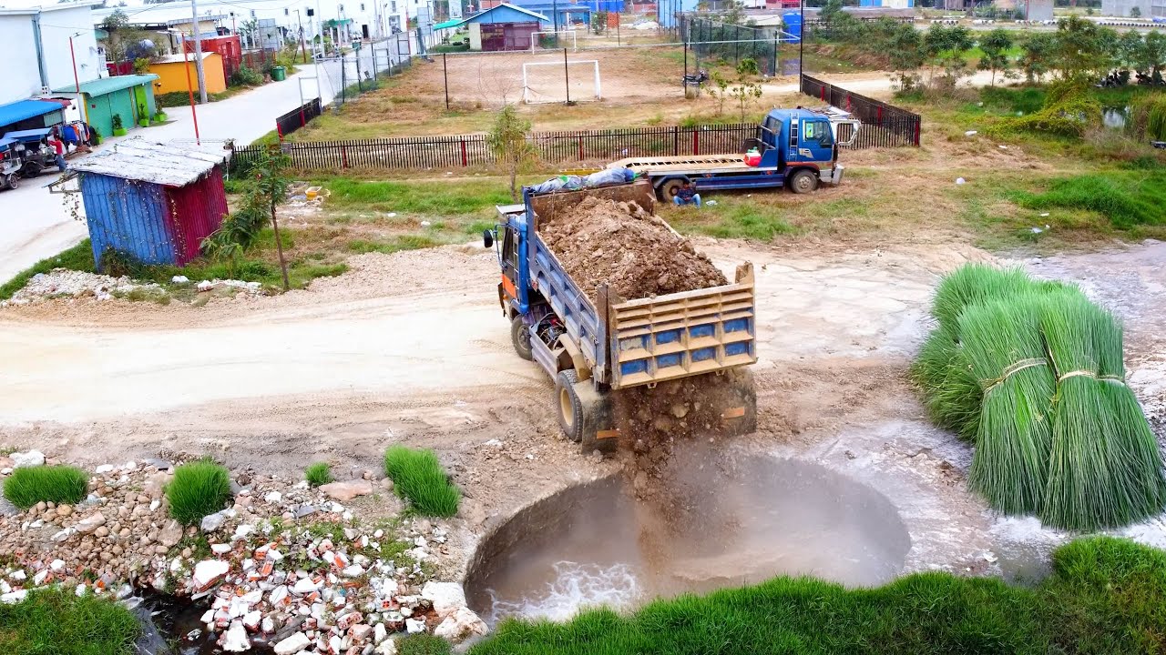 The deep hole filling by soil truck unload and bulldozer pushing