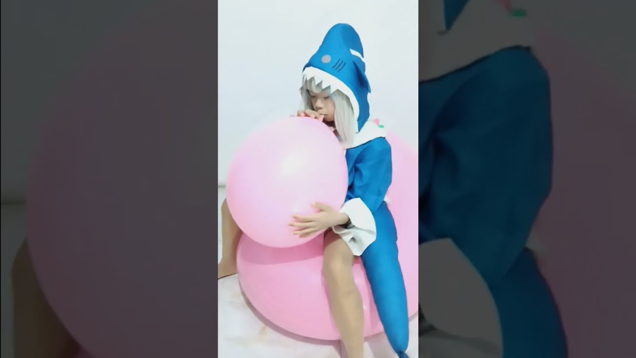 blow pink balloon while sitting on big 36