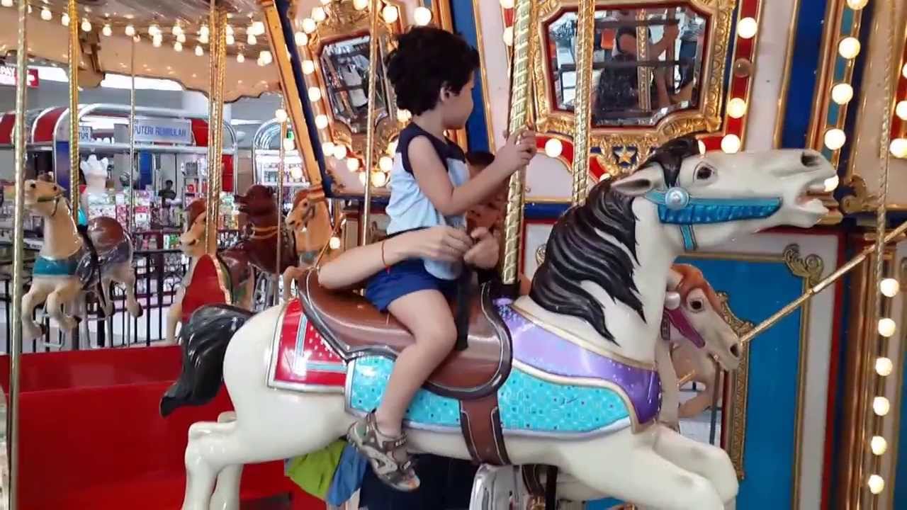 Justin riding a Merry Go Round In IOI Mall