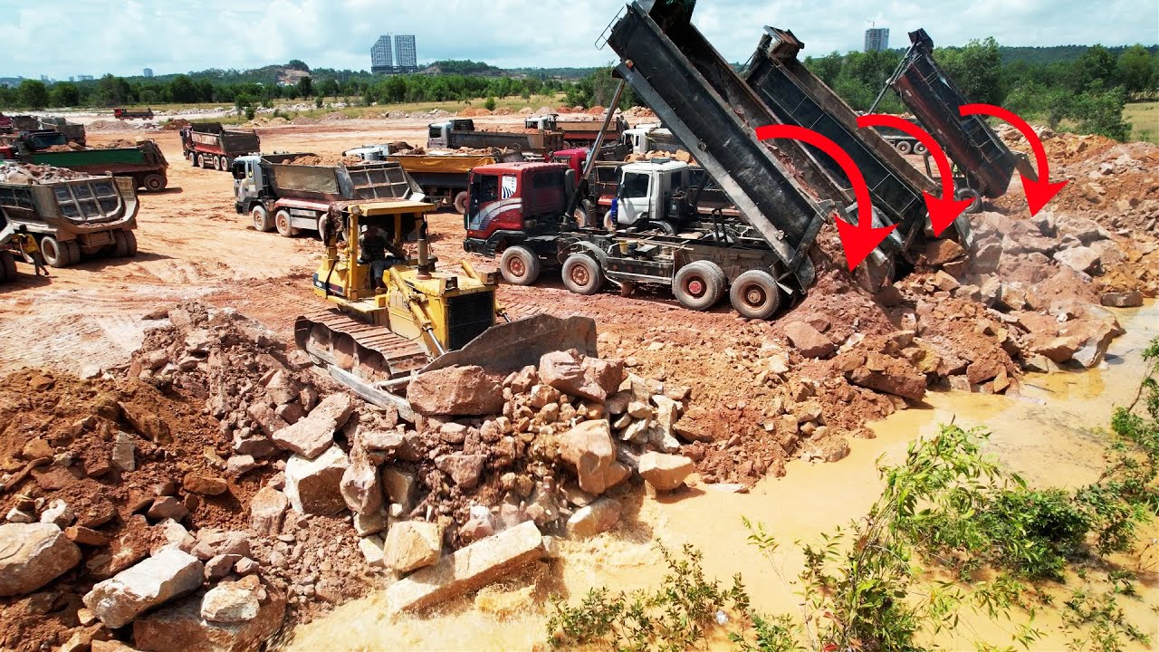 Incredible Strong Power Bulldozer KOMATSU Pushing Stones, 12 Wheel Trucks Unload In Water Land Fill