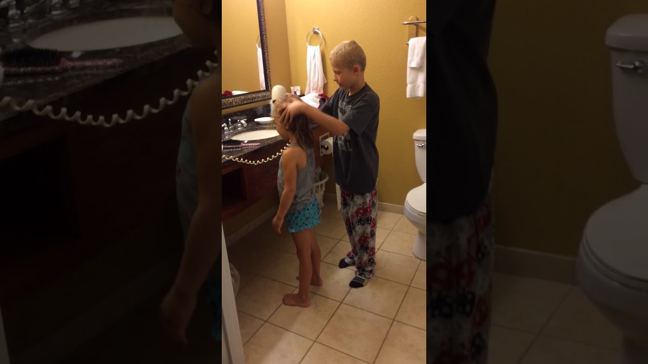 Big brother Keaton brushes and blow dries little sister Maeli’s hair