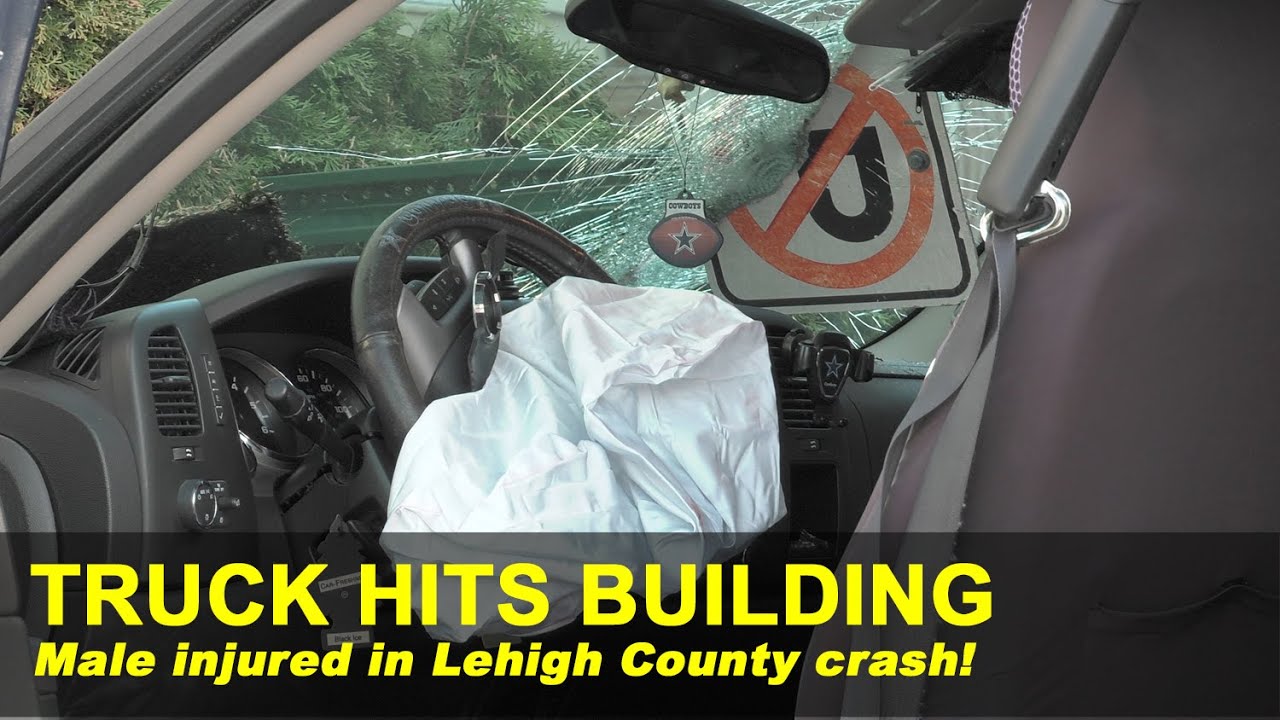 Truck hits apartment building, driver extricated from crash