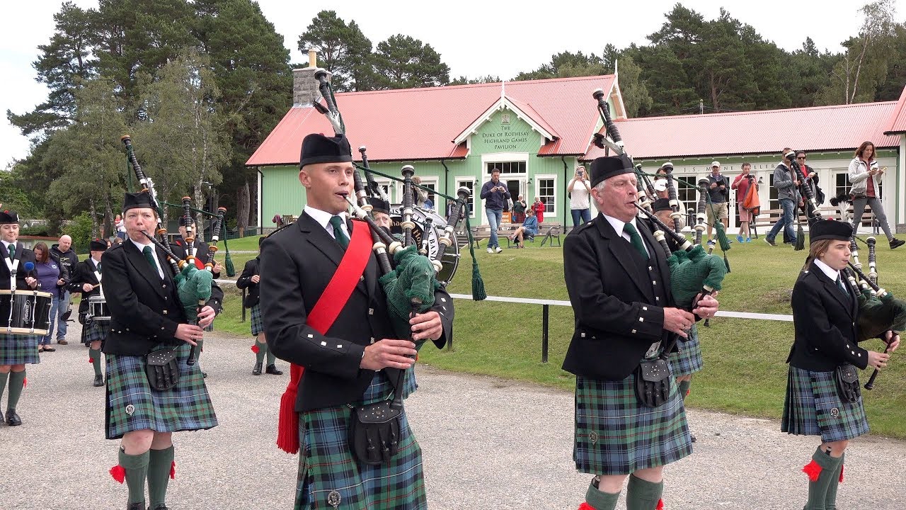 Drum Major Ian Esson leads Ballater Pipe Band through Braemar to the Highland Gathering site