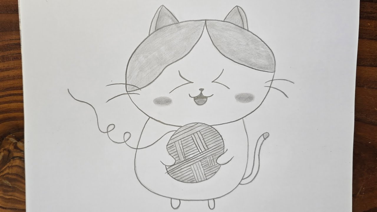 Cute little cat playing with balls of yarn