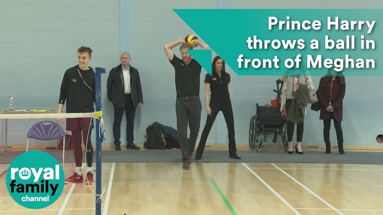 Prince Harry throws a ball in front of Meghan Markle at seated volleyball trials