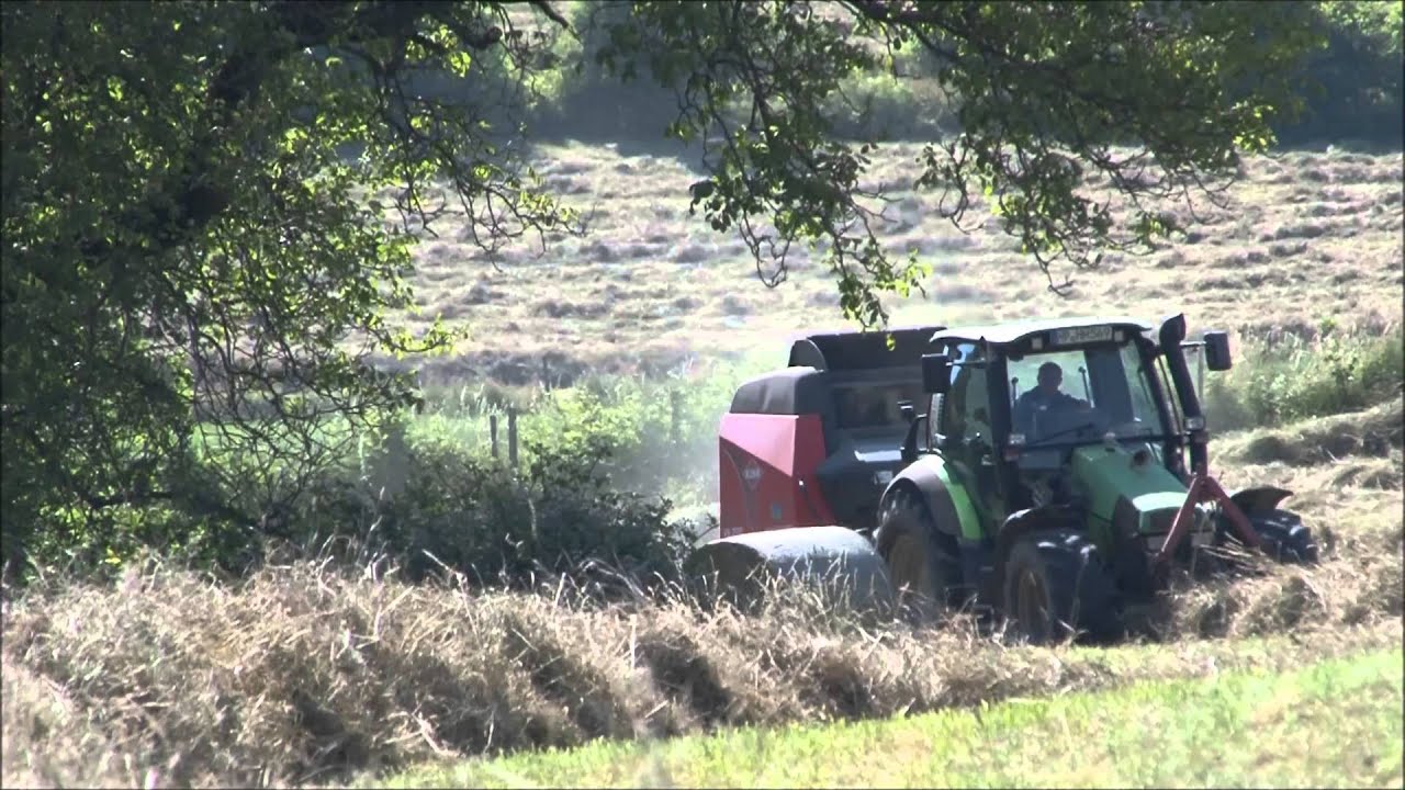 Deutz Agrotron 110 MK3 presst Rundballen am Hang