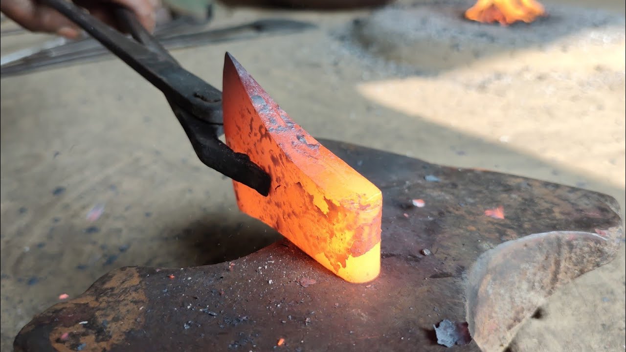 A blacksmith makes an axe from a rusty truck leaf spring.