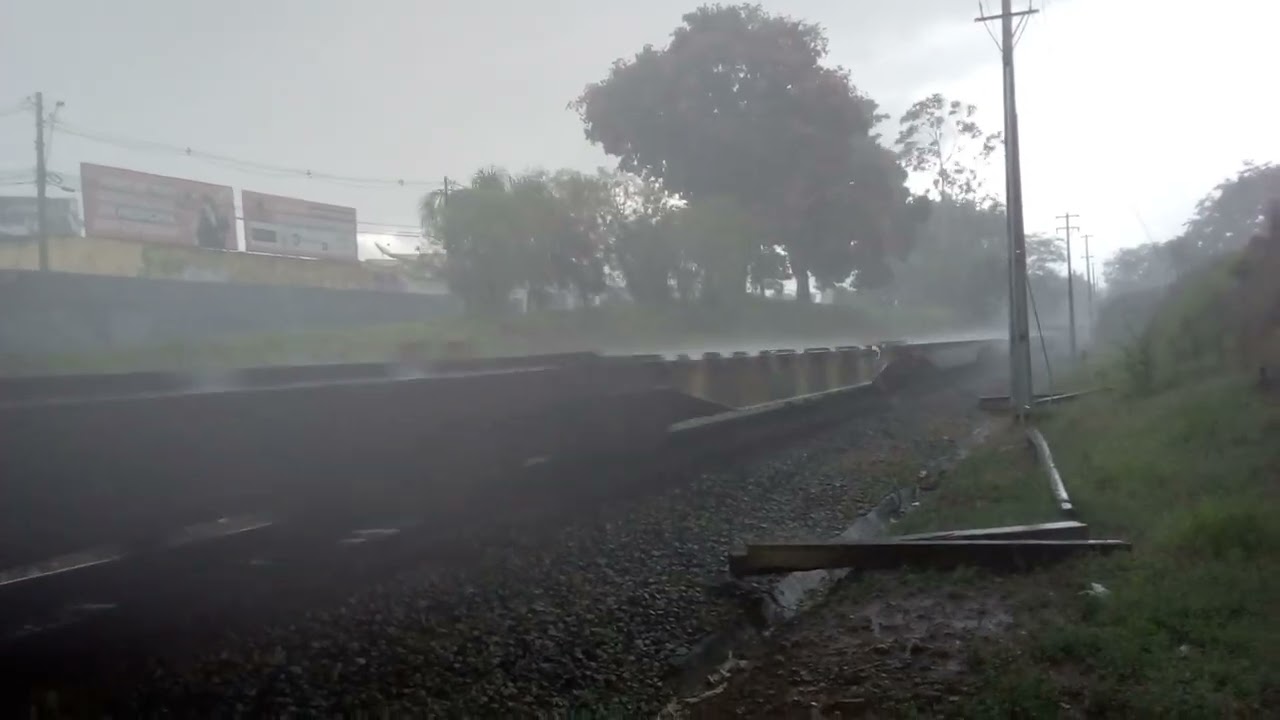 Carga geral, trem da MRS passando em Taubaté com 2 locomotivas em uma forte chuva.