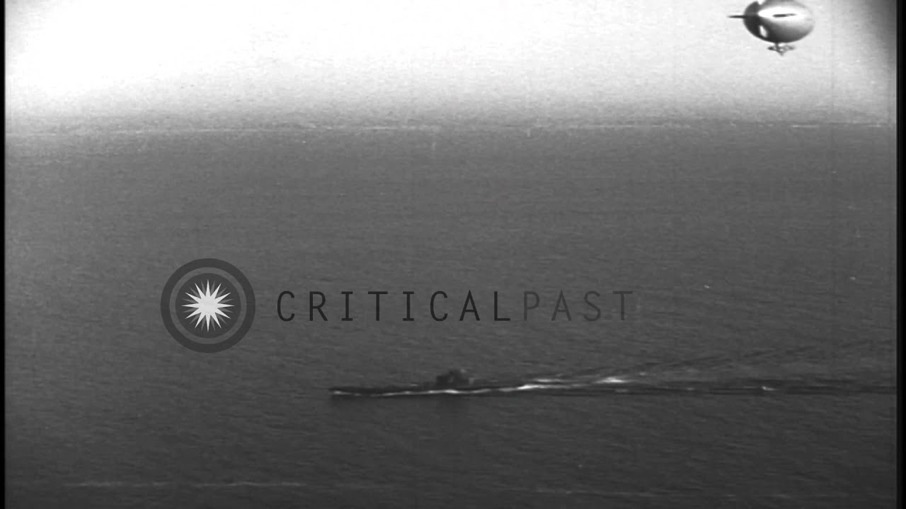 US submarine underway in the Pacific Ocean and K-class blimp in flight overhead HD Stock Footage