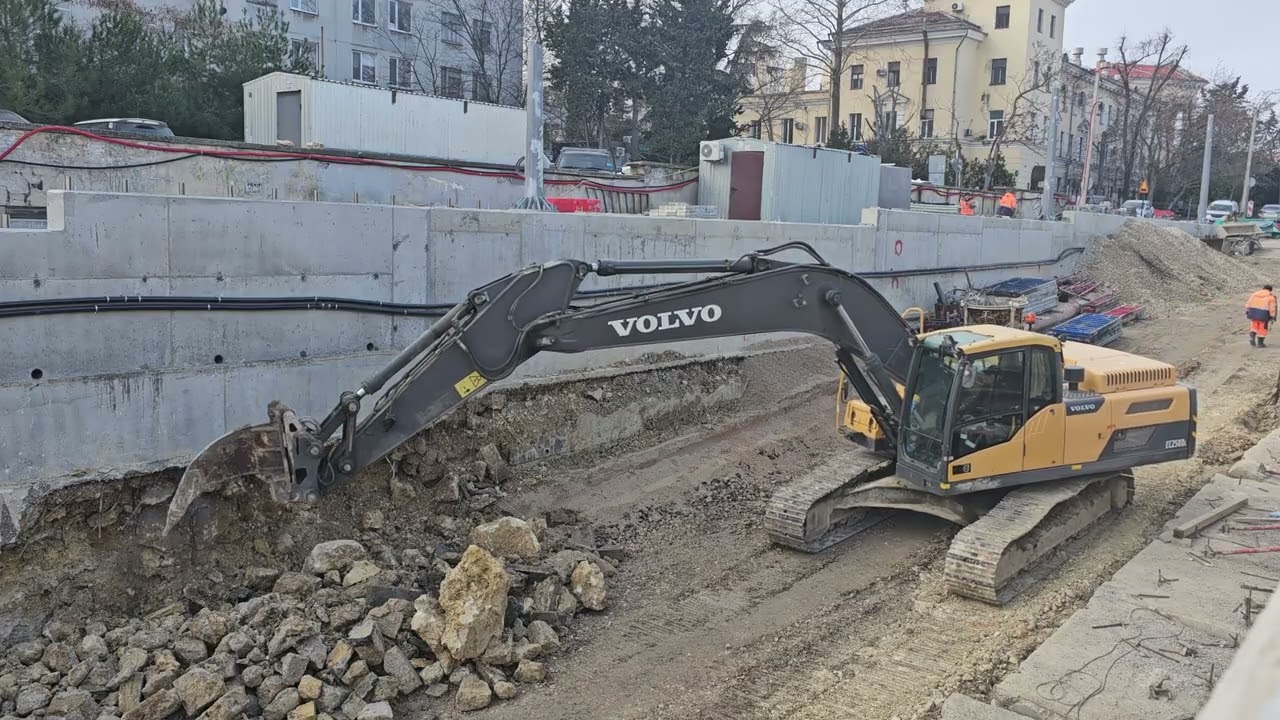 Volvo EC250DL демонтирует рыхлителем фрагменты старой подпорной стены
