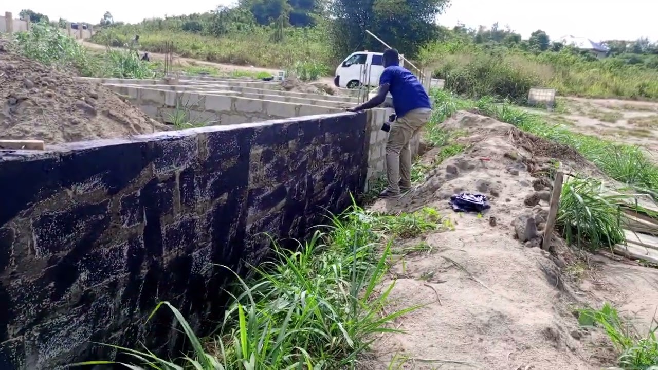 Asebu Pan African Project: Applying Damp proof paint on a wall in waterlogged area