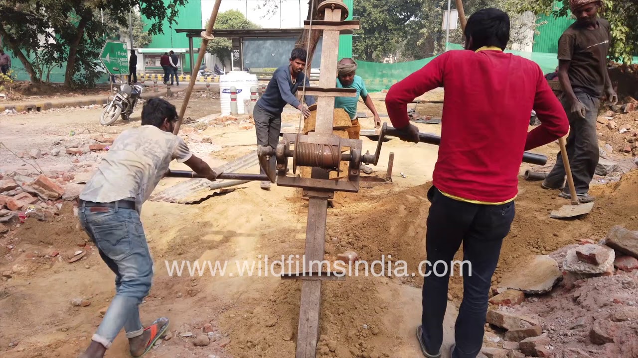 Manual labourers drilling borehole manually like medieval times | Manual drilling machine at work