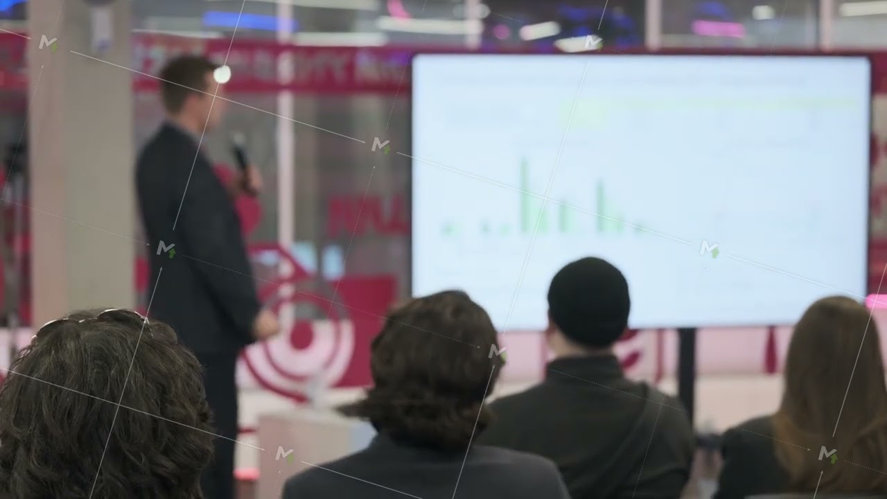 Business presentation with speaker and audience watching large screen at conference meeting