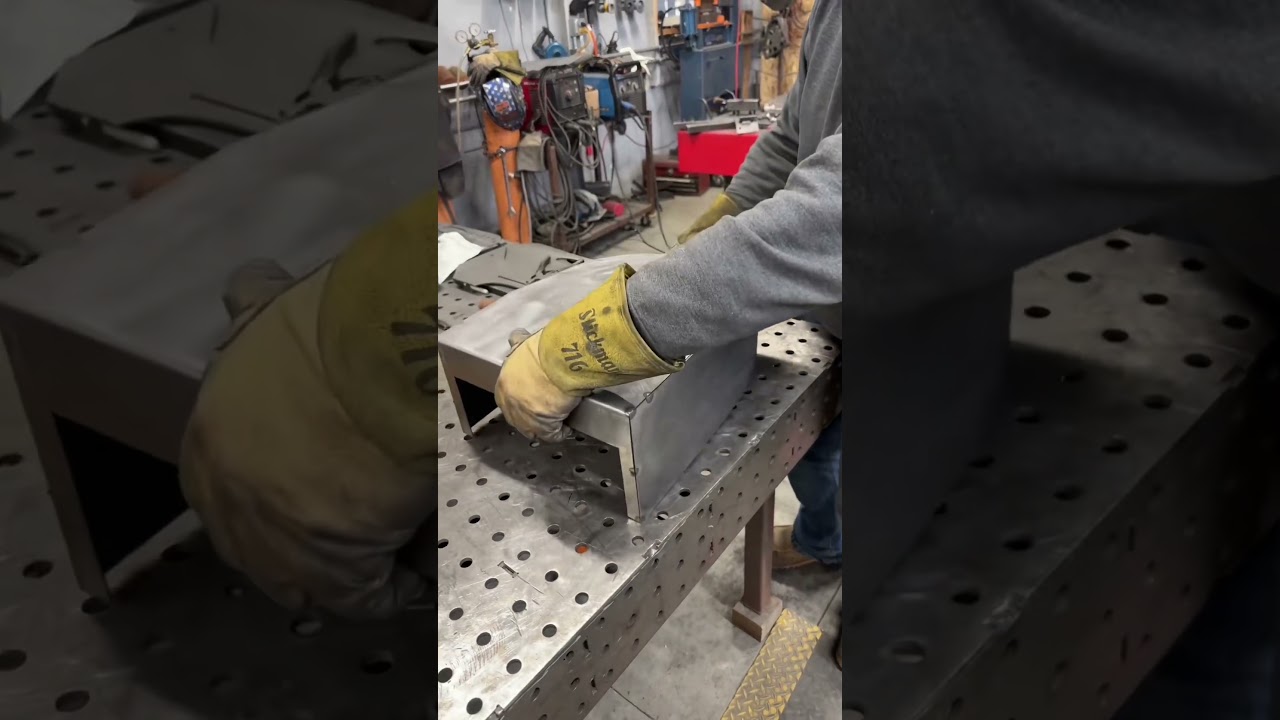Using a handheld laser welder in the shop to weld a steel guard with a clean fusion weld.