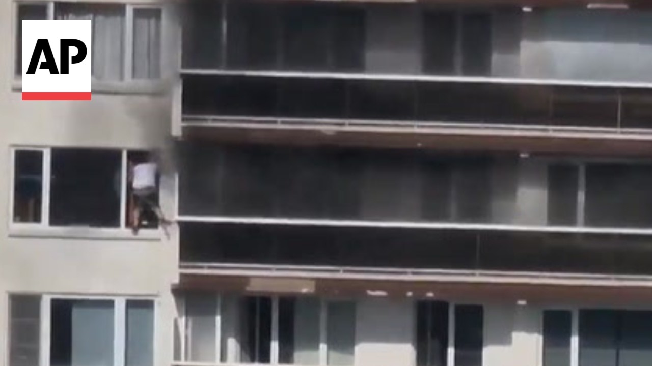 Dramatic video shows man escaping an apartment fire through a window in Belgium