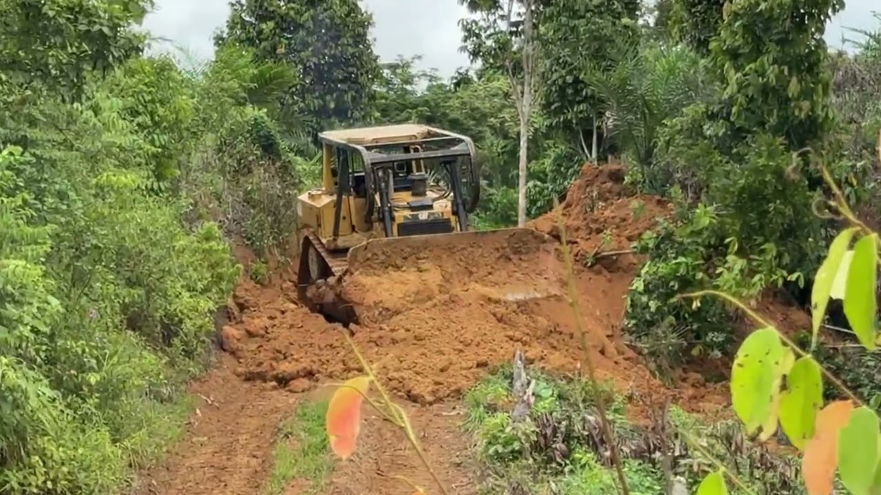 The CAT D6R XL bulldozer is building a road for the first time on the side of a mountain hill