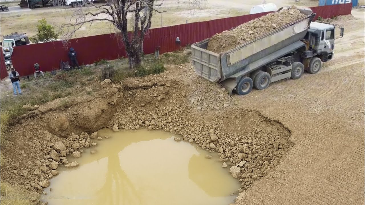 25T Dump Trucks Loading Rock Soil Fill The Land With An Old Strong Bulldozer