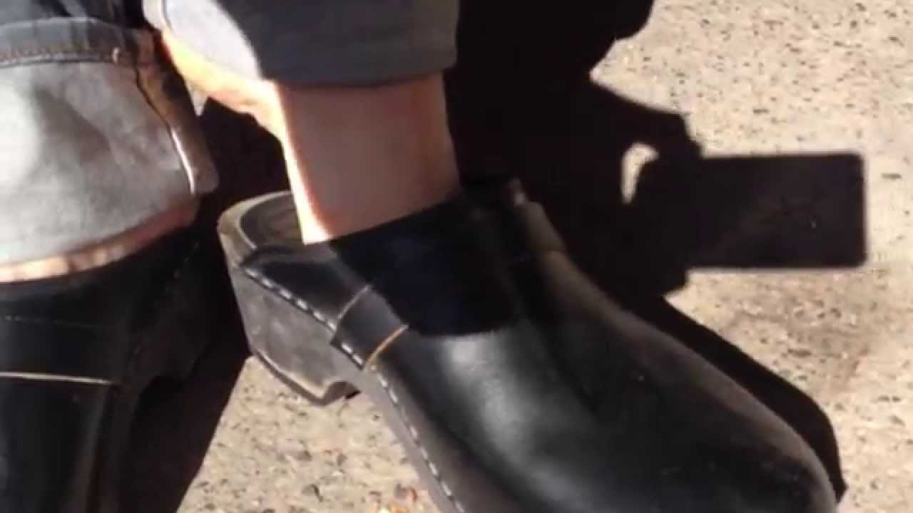 wooden clogs on concrete floor in public , male  barefoot