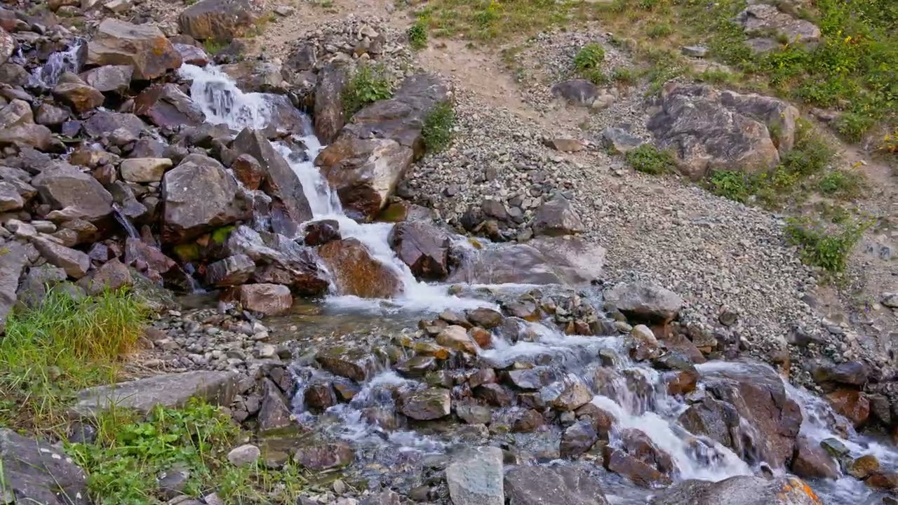 Serene waterfall flowing over rocks in mountainous terrain