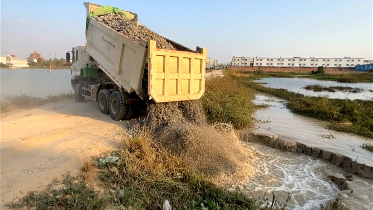 Starting New project landfill flooded Area by dump truck wheel 10 unloading rock & Bulldozer pushing