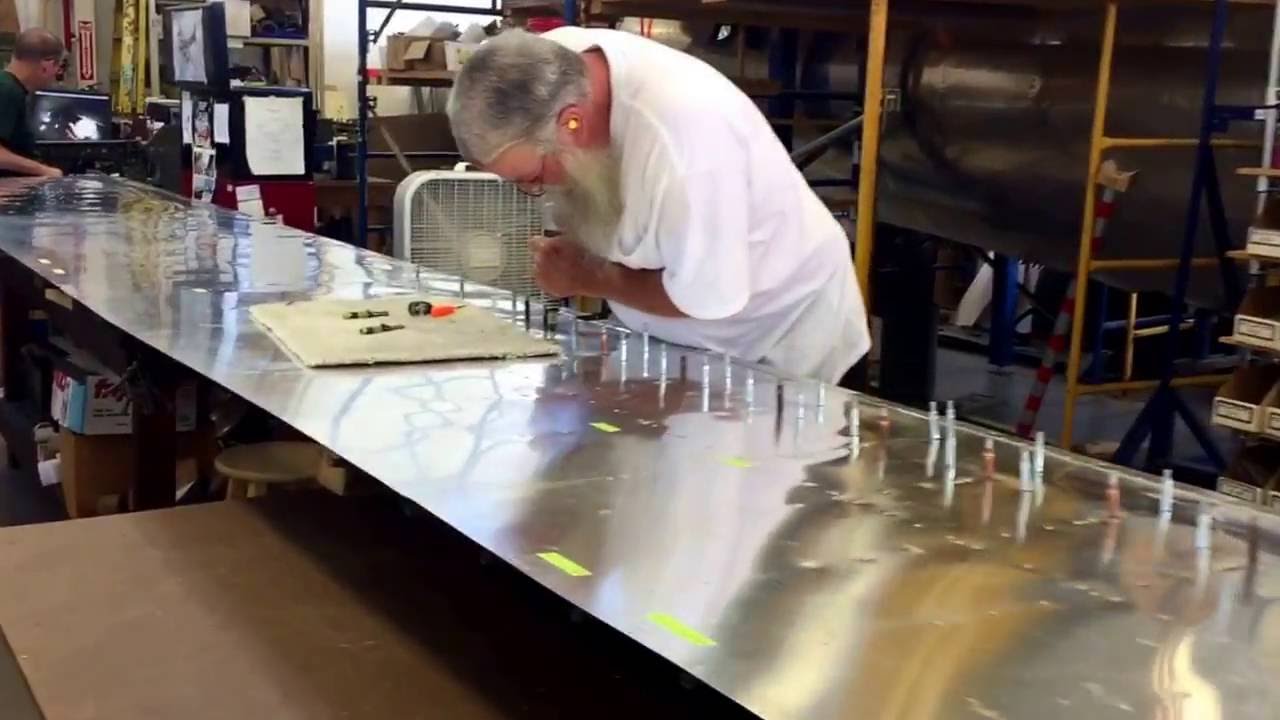 Riveting one of the wing flaps to a B-17 Flying Fortress.
