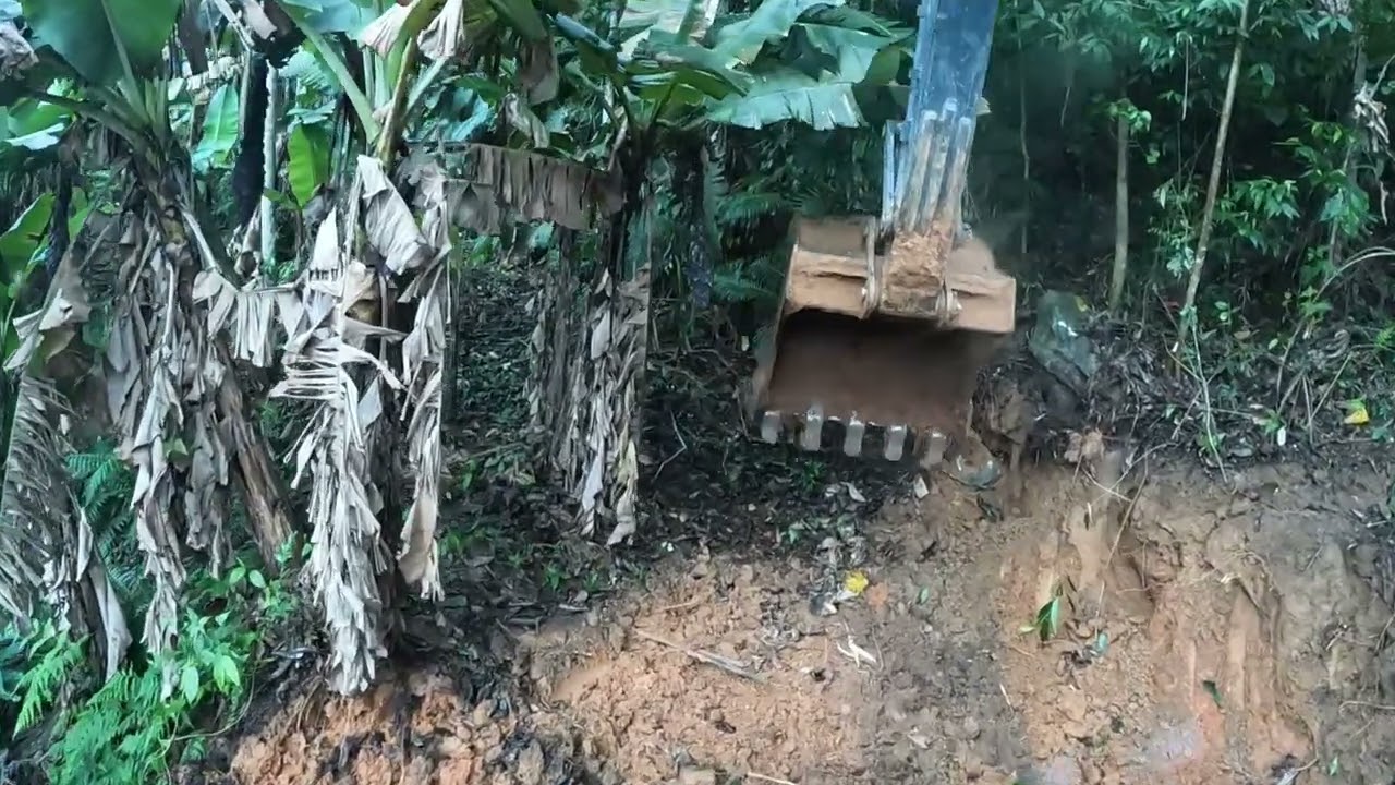 Escavadeira abrindo estrada muito apertada