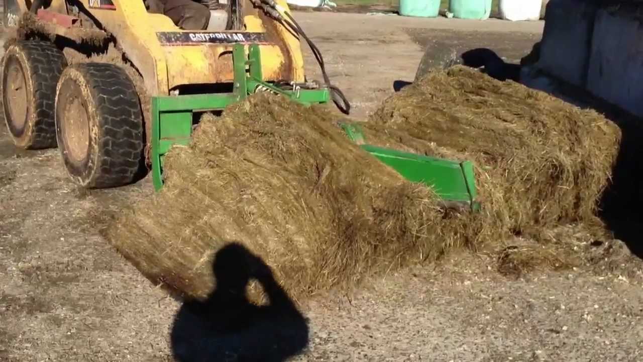 Cutting a round bale in half with Mchale Bale Knive & Caterpillar 262B SkidSteer