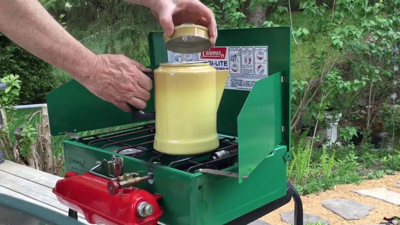 Coleman Camp Stove brewing coffee with a percolator.