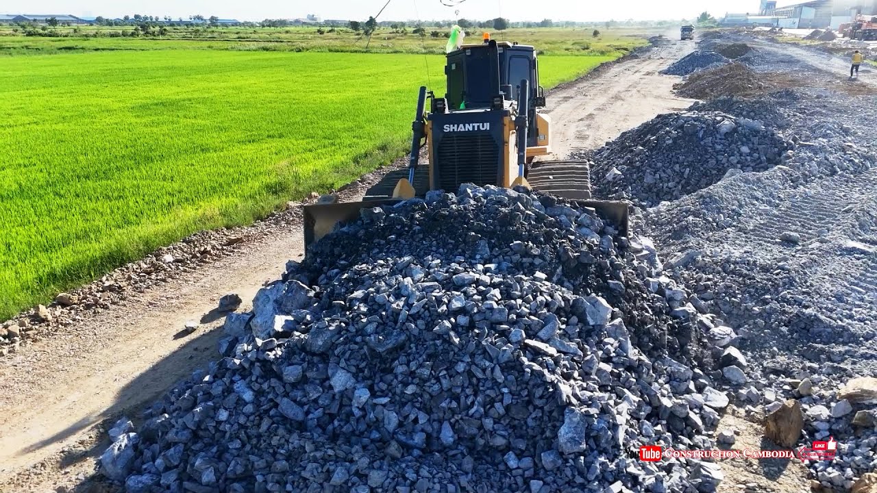 Skilled Operator Uses Bulldozer Pushing Stones & Dump Trucks Filling Stones to Build Road Foundation