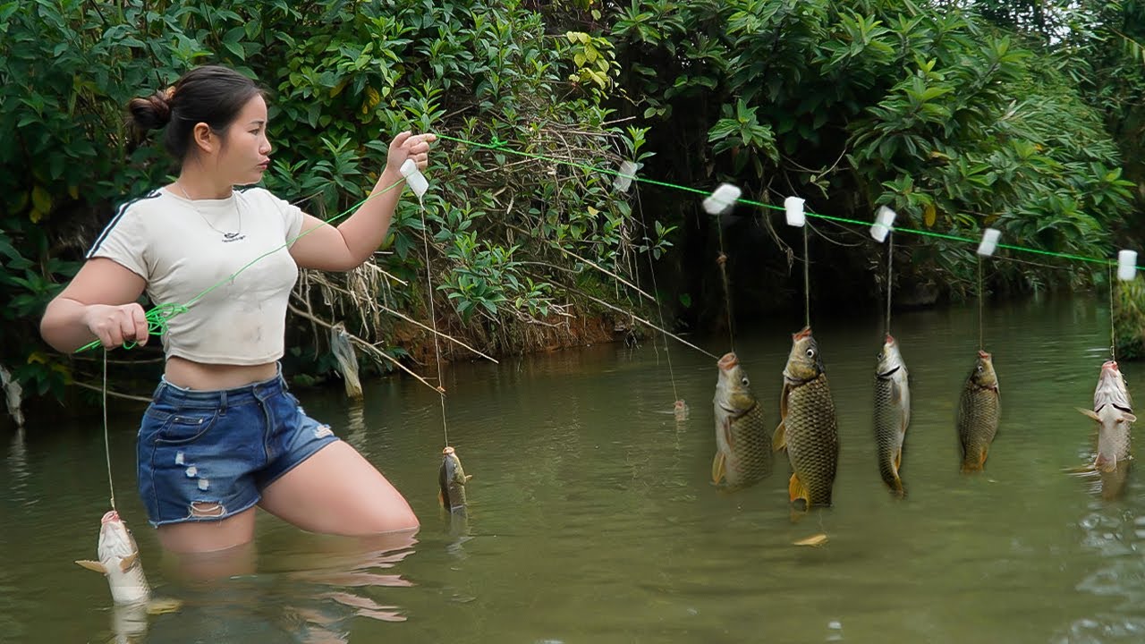 The girl caught many stream fish with a hook and bamboo basket.