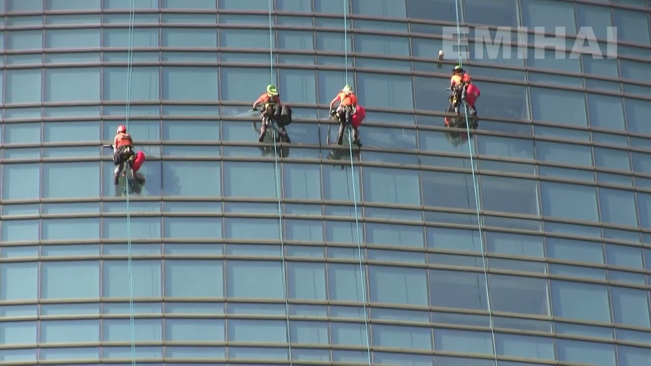 Windows cleaners climbers at work on Unicredit Tower skycraper, Milan, Italy