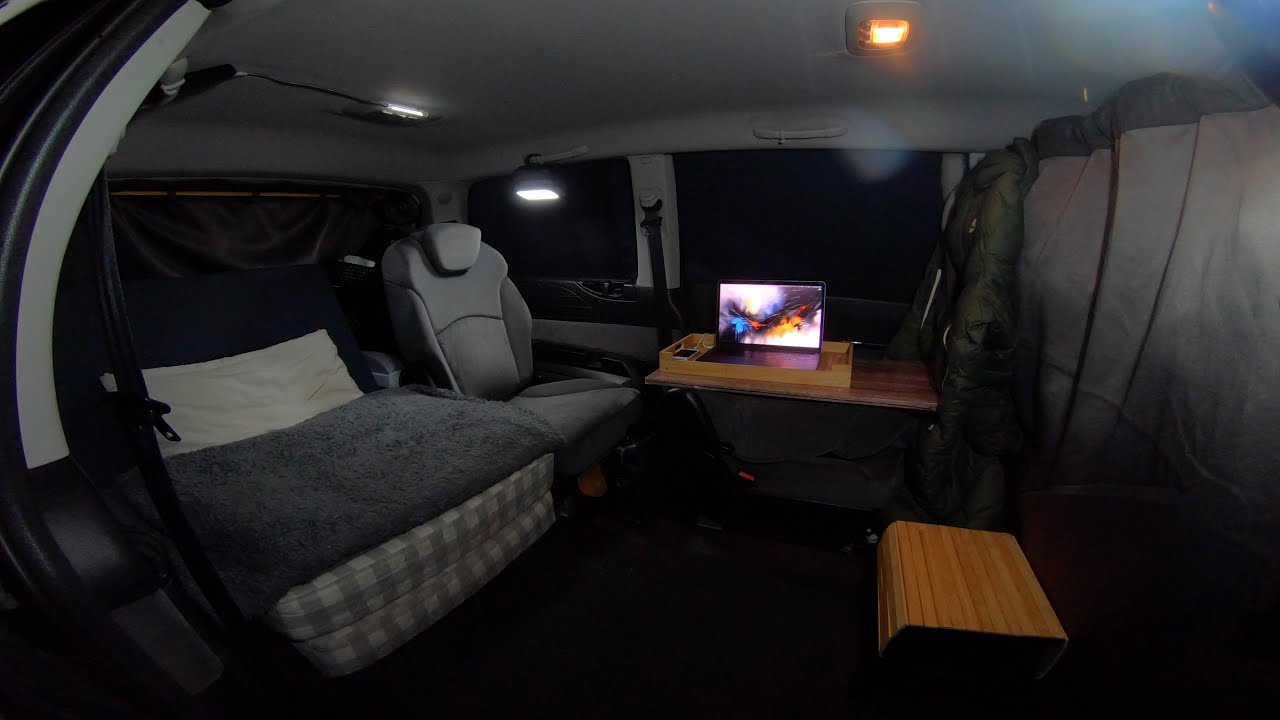 Camping dans la voiture au bord du lac sous la pluie