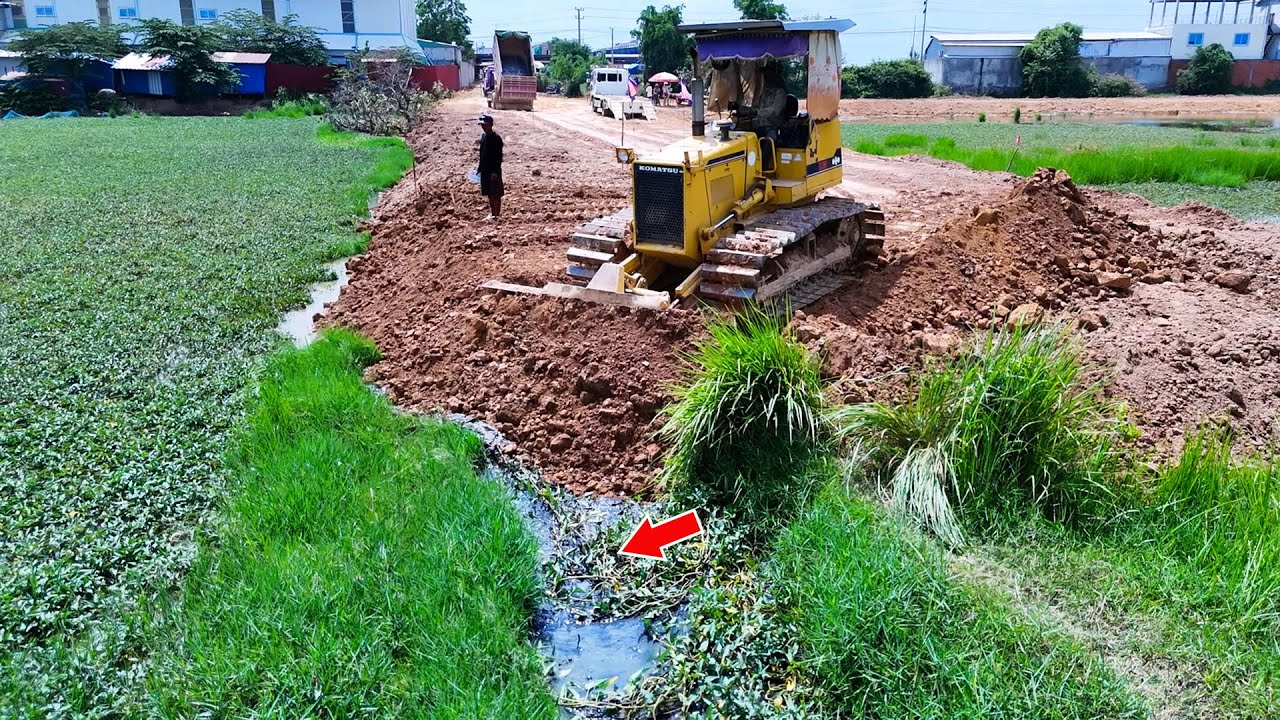 Nice skill bulldozer operator pushing soil perfectly with dump trucks