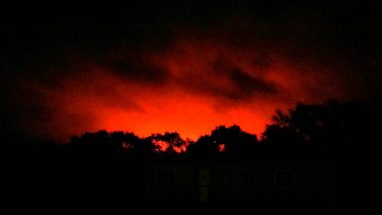 Oil well flare burning on a cloudy night